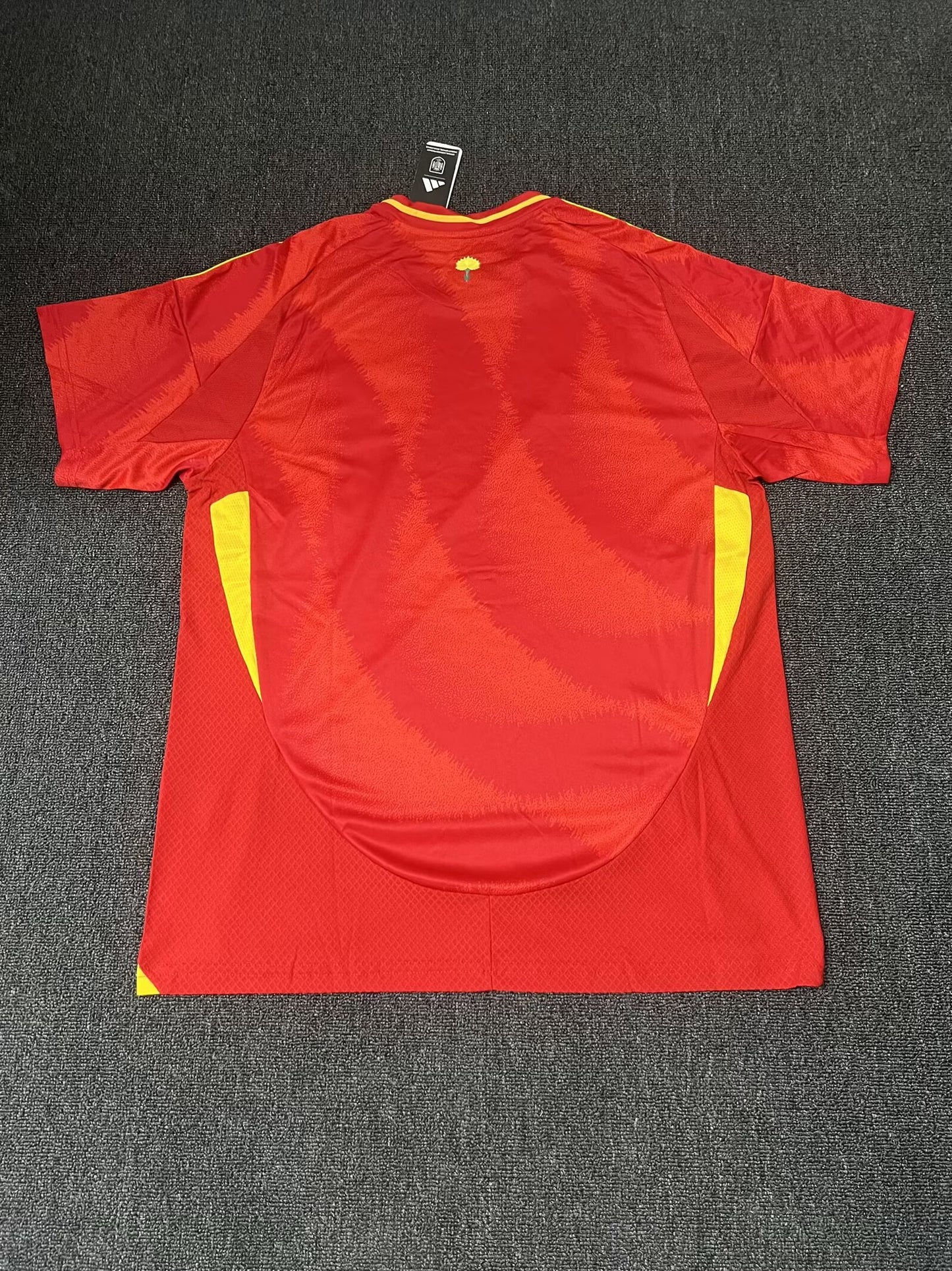 Red sports jersey with yellow accents on a dark gray background
