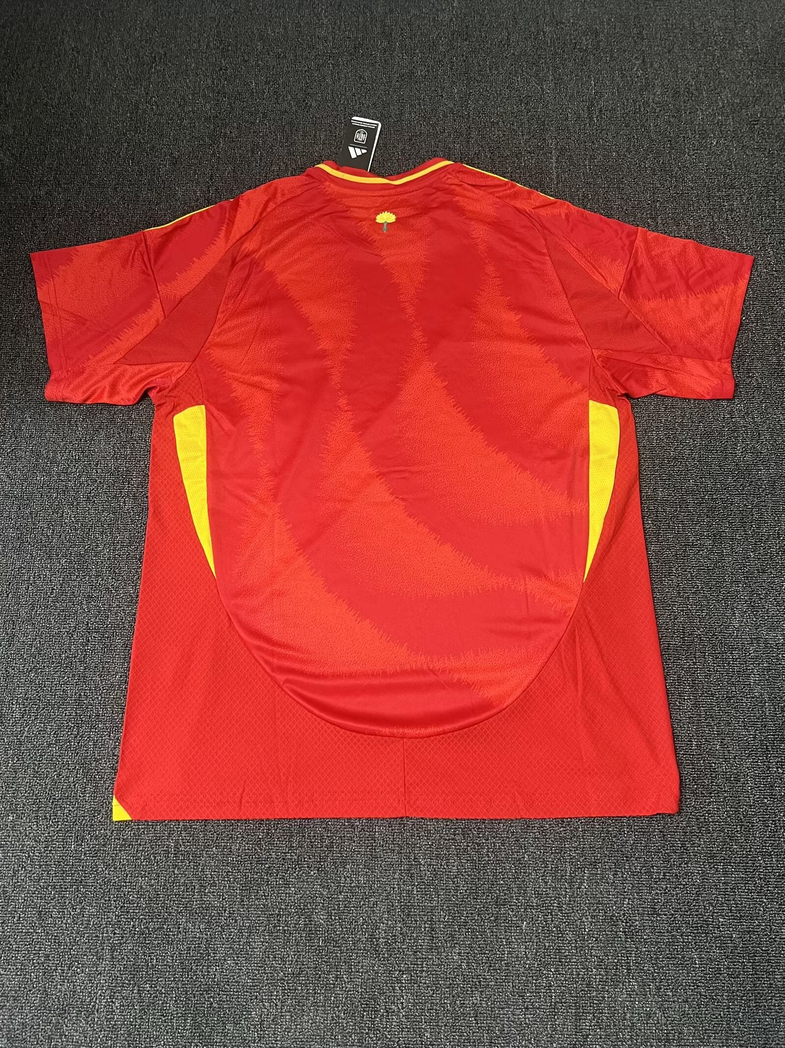 Red sports jersey with yellow accents on a dark gray background